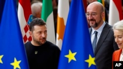 Ukraine's President Volodymyr Zelenskyy, left, European Commission President Ursula von der Leyen, right, and European Council President Charles Michel arrive for a group photo during an EU summit in Brussels, Oct. 17, 2024. 