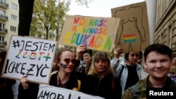 FILE - People take part in demonstration for LGBT rights in front of the Education ministry in Warsaw, Poland, Oct. 25, 2019.