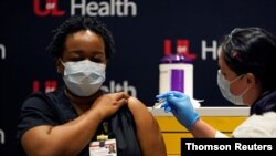 LaShawn Scott, a nurse at University of Louisville Hospital, is inoculated with the Pfizer coronavirus disease (COVID-19) vaccine at The University of Louisville Hospital in Louisville, Kentucky, December 14, 2020.
