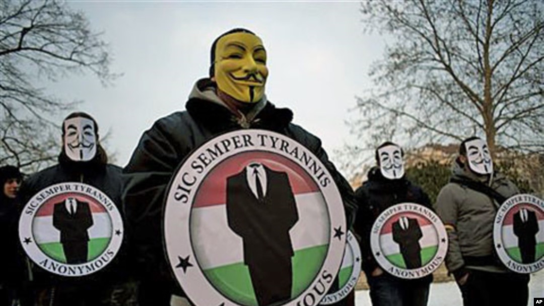 Protestors wearing Guy Fawks masks hold the logos of the international hacker group Anonymous during a demonstration against Anti-Counterfeiting Trade Agreement, ACTA, in Budapest, Hungary, February 11, 2012.