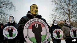 Protestors wearing Guy Fawks masks hold the logos of the international hacker group Anonymous during a demonstration against Anti-Counterfeiting Trade Agreement, ACTA, in Budapest, Hungary, February 11, 2012.
