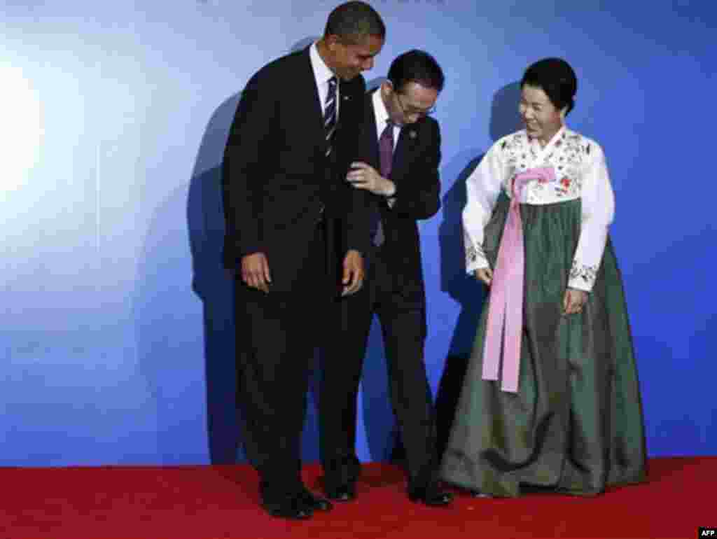 South Korean President Lee Myun-bak, center, and his wife Kim Yoon-ok, right, reposition President Barack Obama for a photo for the official arrival and reception at the G-20 summit in Seoul, South Korea, Thursday, Nov. 11, 2010. (AP Photo/Charles Dharapa