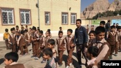 FILE - Iranian and Afghan boys play outside at the Be'sat school in Kerman, Iran, Oct. 23, 2016. 