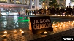 A placard reading "I am Charlie" and candles are placed as a tribute to the victims following a shooting by gunmen at the offices of French weekly newspaper Charlie Hebdo in Paris, during a candlelight vigil at the financial Central district in Hong Kong,