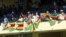 Zimbabweans stand holding flags, during the 36th over of a cricket match between New Zealand and Zimbabwe, at Queens Sports Club in Bulawayo, Zimbabwe, Aug. 6, 2016.
