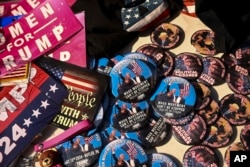 Campaign buttons with likenesses of Donald Trump are seen during the second day of the 2024 Republican National Convention near the Fiserv Forum in Milwaukee, Wisconsin, July 16, 2024.