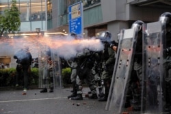 Riot police fire tear gas at protesters in Hong Kong, Aug. 25, 2019.