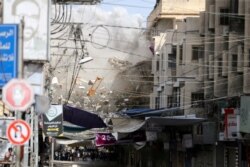 Debris fly as smoke rises following an Israeli air strike, amid Israeli-Palestinian fighting, in Khan Younis in the southern Gaza Strip, May 20, 2021.