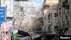 Debris fly as smoke rises following an Israeli air strike, amid Israeli-Palestinian fighting, in Khan Younis in the southern Gaza Strip, May 20, 2021.