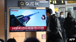 Orang-orang menonton layar televisi yang menayangkan siaran berita tentang penembakan artileri Korea Utara, di stasiun kereta api di Seoul pada 5 Januari 2024. (Foto: AFP)