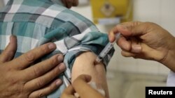 Un agent de santé vaccine un homme lors d'une campagne de vaccination contre la fièvre jaune à Sao Paulo, au Brésil, le 17 janvier 2018.