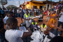 FILE - Election officials count the ballots after polls closed in Kampala, Uganda, Jan. 14, 2021.