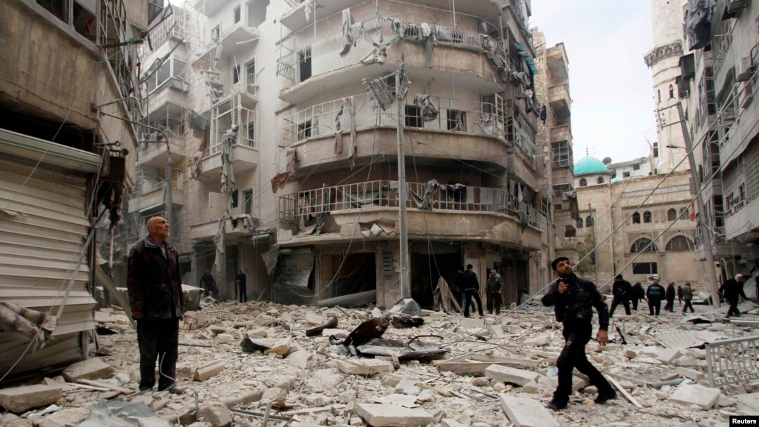 Men inspect the damage at a site hit by what activists said were two barrel bombs dropped by forces loyal to Syria's President Bashar al-Assad in Aleppo's al-Shaar neighborhood Feb. 26, 2015.