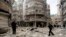 Men inspect the damage at a site hit by what activists said were two barrel bombs dropped by forces loyal to Syria's President Bashar al-Assad in Aleppo's al-Shaar neighborhood Feb. 26, 2015.