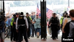 Police officers await the arrival of Jason Kessler at Vienna Metro Station, on the one year anniversary of the 2017 Charlottesville "Unite the Right" protests, in Vienna, Virginia, U.S., August 12, 2018. REUTERS/Lucas Jackson