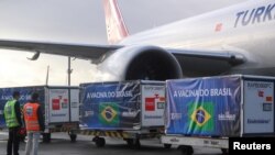 Refrigerated containers with supplies to produce China's Sinovac vaccines against the coronavirus disease arrive at Sao Paulo International Airport in Guarulhos, Brazil, April 19, 2021. The banner reads "Brazil's vaccine."