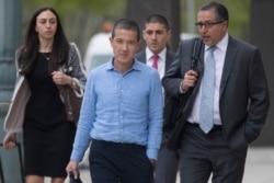 FILE - Former Goldman Sachs executive Roger Ng, center, leaves Brooklyn Federal court with attorney Marc Agnifilo, right, May 6, 2019, in New York.