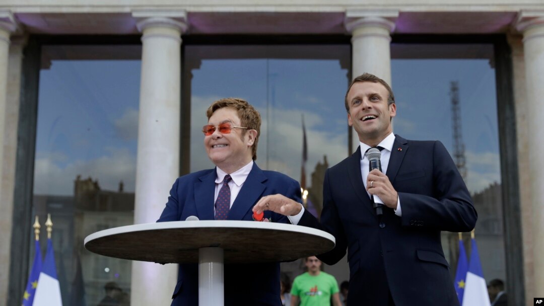 Presiden Perancis Emmanuel Macron (kanan) dan Sir Elton John di halaman Istana Elysee, Paris, Perancis, 21 Juni 2019. (Foto: dok). 