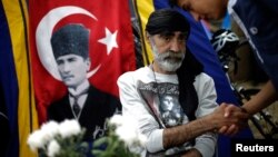 Protesters greet each other near a portrait of Mustafa Kemal Ataturk, founder of modern Turkey, at Gezi Park near Taksim Square in Istanbul, June 6, 2013. 