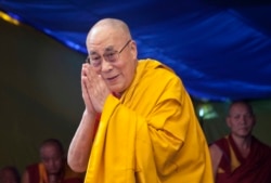 FILE - Tibetan spiritual leader the Dalai Lama greets devotees as he arrives to give a religious talk at the Tibetan Children's Village School in Dharmsala, India, May 27, 2015.