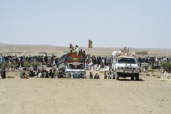 FILE - Afghan traders and citizens gather near the Pakistan's newly inaugurated Badini&nbsp;Trade&nbsp;Terminal&nbsp;Gateway, a border crossing point between Pakistan and Afghanistan at the country's border town of Qila Saifullah, Sept. 16, 2020.