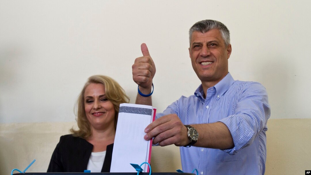 Perdana Menteri Kosovo Hashim Thaci, bersama istrinya Lumnije, memberikan suara di sebuah TPS di ibukota Pristina, Minggu (8/6). (AP/Visar Kryeziu)
