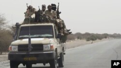 FILE - Chadian troops ride toward the Lake Chad region, near the Nigeria border, March 6, 2015. 