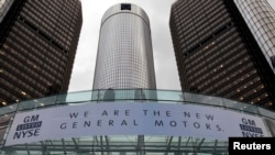 FILE - A banner hangs at the front of the General Motors Co world headquarters in Detroit, Michigan.