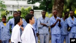 Elementos dos Caminhos de Ferro Chineses envolvidos na construção de uma estrada em Kinshasa, recebidos por trabalhadores congoleses