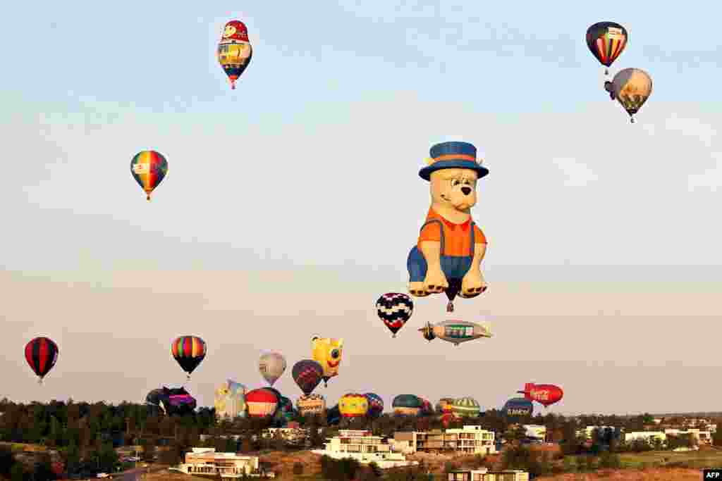 Some of the 100 hot air balloons that participate in the International Hot Air Balloon Festival, fly over Leon, Guanajuato state, Mexico, Nov. 14, 2020.