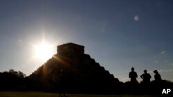 People gather in front of the Kukulkan Pyramid in Chichen Itza, Mexico, Thursday, Dec. 20, 2012. American seer Star Johnsen-Moser led a whooping, dancing, drum-beating ceremony Thursday in the heart of Mayan territory to consult several of the life-sized crystal skulls, which adherents claim were passed down by the ancient Maya. (AP Photo/Israel Leal)