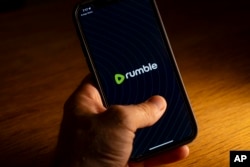 An iPhone displays the logo for the Rumble app, September 23, 2023, in Washington. Rumble, an alternative video sharing platform, has been criticized for allowing far-right extremism, bigotry, election disinformation and conspiracy theories.