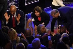 Democratic presidential hopefuls, from left, Cory Booker and Amy Klobuchar greet supporters as Jay Inslee greets U.S. activist Al Sharpton after the first Democratic primary debate of the 2020 presidential campaign in Miami, June 26, 2019.