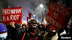 A demonstrator holds a placard during a protest against the verdict restricting abortion rights in Warsaw, Poland, Jan. 28, 2021.