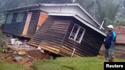 A local resident stands next to a damaged house near a landslide in the town of Tari after an earthquake struck Papua New Guinea's Southern Highlands, in this image taken Feb. 27, 2018, obtained from social media.