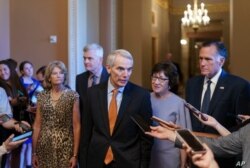 Los senadores republicanos Rob Portman, centro, junto con, de izquierda, Lisa Murkowski, Bill Cassidy, Susan Collins, y Mitt Romney, anuncian un acuerdo con los demócratas en un paquete de infraestructura de $ 1 billón, en el Capitolio en Washington.