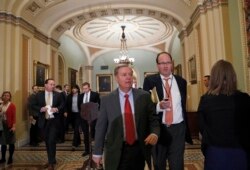 FILE - Senator Lindsey Graham walks with a reporter on Capitol Hill in Washington, April 19, 2019..