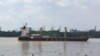 A container ship moves along the Saigon River, used to ship the kinds of exports that have increased Vietnam’s role in global trade.