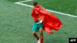 Le Marocain Faycal Fajr couvert du drapeau de son pays quitte le terrain en pleurs après le match du groupe B entre le Portugal et le Maroc lors de la Coupe du monde de football 2018 au stade Luzhniki à Moscou, Russie, m20 juin 2018.