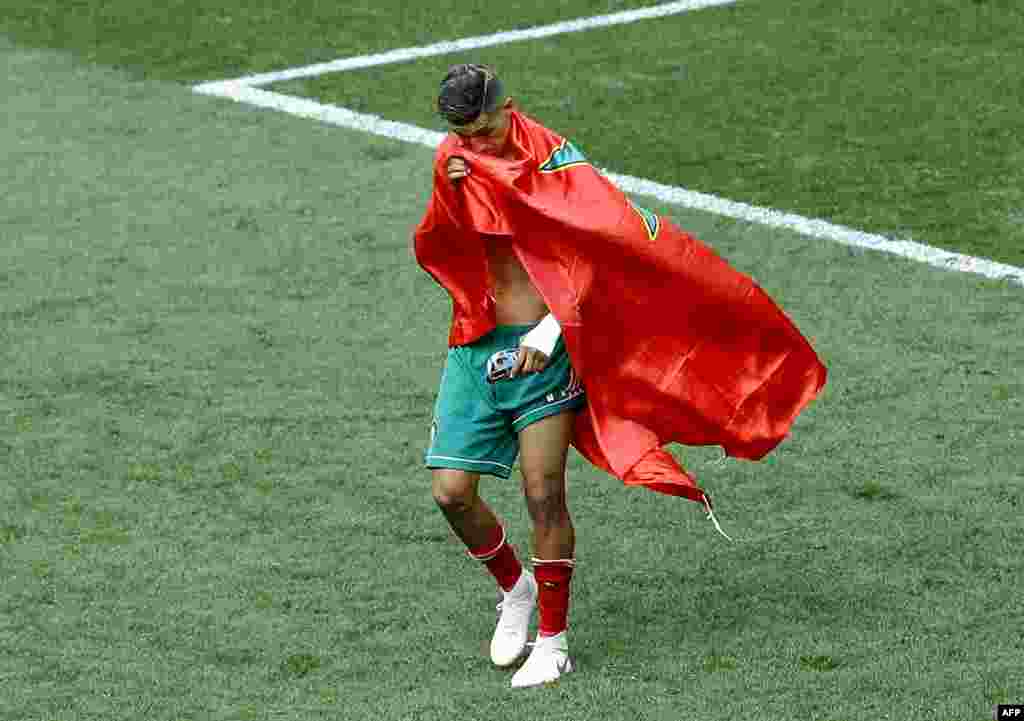 Le Marocain Faycal Fajr couvert du drapeau de son pays quitte le terrain en pleurs après le match du groupe B entre le Portugal et le Maroc lors de la Coupe du monde de football 2018 au stade Luzhniki à Moscou, Russie, m20 juin 2018.