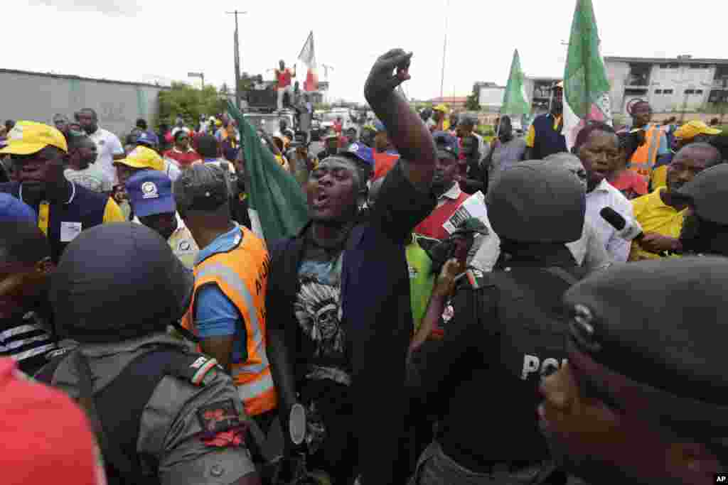 Kungiyar kwadago ta TUC da &#39;ya&#39;yan kungiyoyin al&#39;umma a Lagos suna zanga-zanga a daidai lokacin da suke wuce wani gidan mai dake dauke da sabon farashin man, a Lagos, Najeriya, Laraba 18 Mayu, 2016.