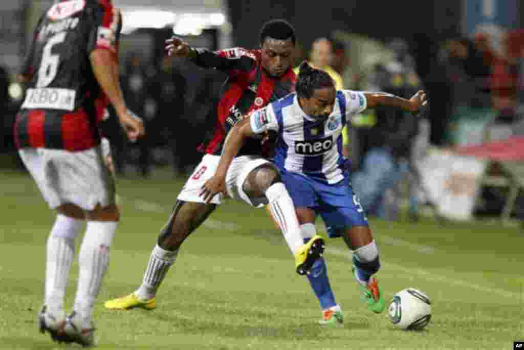 Porto's Alvaro Pereira, right, from Uruguay, battles for the ball with Olhanense's Edson Sitoe "Mexer", from Mozambique, during their Portuguese league soccer match Saturday, Nov. 5, 2011 at the Jose Arcanjo stadium in Olhao, southern Portugal. The game e