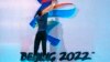 FILE - A crew member leaps to fix a logo for the 2022 Beijing Winter Olympics before a launch ceremony to reveal the motto for the Winter Olympics and Paralympics in Beijing, Sept. 17, 2021.