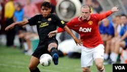 Jonathan dos Santos, Barcelona (kiri) dan Wayne Rooney, Manchester United, dalam sebuah pertandingan bola di tahun 2011. 