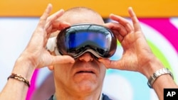 Scott Joachim tries out an Apple Vision Pro headset during the first day of sales at a Palo Alto, Calif., Apple store on Friday, Feb. 2, 2024. (AP Photo/Noah Berger)