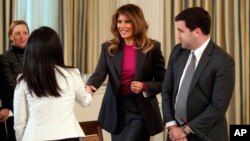 La Primera Dama de EE.UU., Melania Trump, habla con la Directora de Políticas Públicas de Snap, Jennifer Park Stout, a la izquierda, y el Director de Política Pública de Twitter, Carlos Monje, a la derecha, al llegar a una mesa redonda sobre acoso cibernético, en el comedor de Estado de la Casa Blanca. Marzo 20 de 2018.