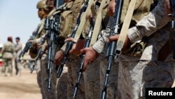 FILE - Saudi soldiers stand in line at an airfield where Saudi military cargo planes land to deliver aid in Marib, Yemen, Jan. 26, 2018. 