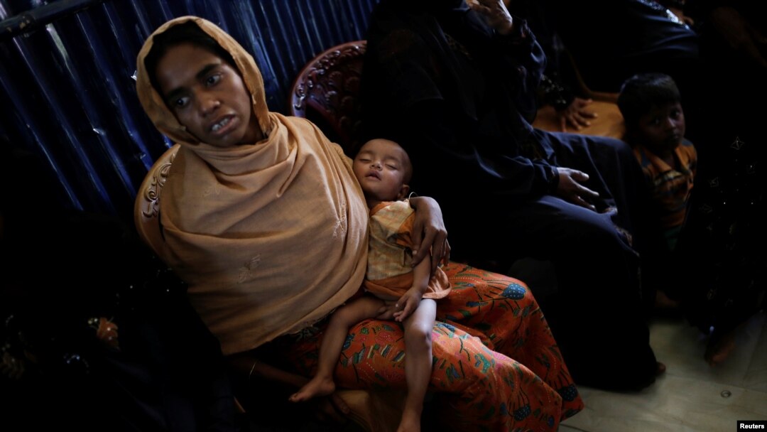 A Rohingya refugee waits for her baby to be examined by doctors at the UNICEF health center at the Kutupalong refugee camp near Cox's Bazar, Bangladesh, Dec. 12, 2017. 