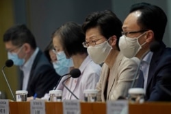 Hong Kong Chief Executive Carrie Lam, second from right, listens to reporters questions during a press conference, July 19, 2020.