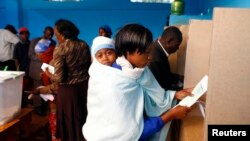 Une femme vote dans un bureau dans la ville de Gatundu, au Kenya, le 4 mars 2013.